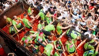 La Tomatina melambangkan semangat kebersamaan ala Spanyol. Orang-orang saling melempar tomat ke satu sama lain dalam suasana yang gembira. Foto: AP/Reuters/Shutterstock