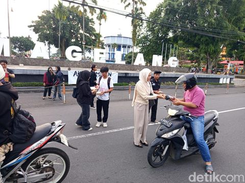 Massa Aksi Kamisan Magelang membagikan nasi bungkus ke pengguna jalan di Alun-Alun Kota Magelang, Kamis (11/9/2025).