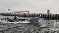 Nelayan melintas diantara tanggul di kawasan Cilincing, Jakarta Utara, Kamis (11/9/2025). Tanggul beton itu disebut mengganggu aktivitas nelayan setempat.