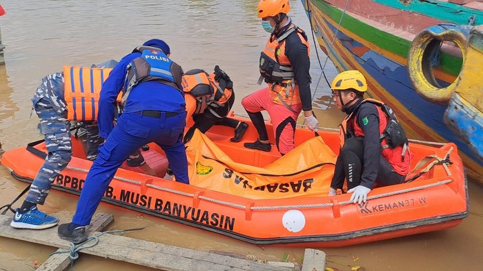 Petugas saat mengevakuasi jasad operator ekskavator yang tenggelam di Muba