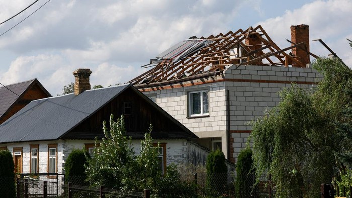 Polish soldiers walk below as firefighters work on the destroyed roof of a house, after Russian drones violated Polish airspace during an attack on Ukraine, with some being shot down by Poland with the backing from its NATO allies, in Wyryki-Wola, Lublin Voivodeship, Poland, September 10, 2025. REUTERS/Kacper Pempel     REFILE - CORRECTING LOCATION FROM 
