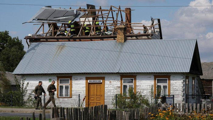 Polish soldiers walk below as firefighters work on the destroyed roof of a house, after Russian drones violated Polish airspace during an attack on Ukraine, with some being shot down by Poland with the backing from its NATO allies, in Wyryki-Wola, Lublin Voivodeship, Poland, September 10, 2025. REUTERS/Kacper Pempel     REFILE - CORRECTING LOCATION FROM 