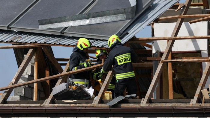 Polandia Tembak Jatuh Drone Rusia, Puing Hantam Rumah Warga Polish soldiers walk below as firefighters work on the destroyed roof of a house, after Russian drones violated Polish airspace during an attack on Ukraine, with some being shot down by Poland with the backing from its NATO allies, in Wyryki-Wola, Lublin Voivodeship, Poland, September 10, 2025. REUTERS/Kacper Pempel REFILE - CORRECTING LOCATION FROM