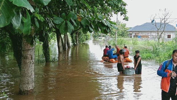 Polisi mengevakuasi lansia sakit dan bocah digigit ular dari perumahan yang terendam banjir di Pekanbaru, Riau, Kamis (10/9/2025).