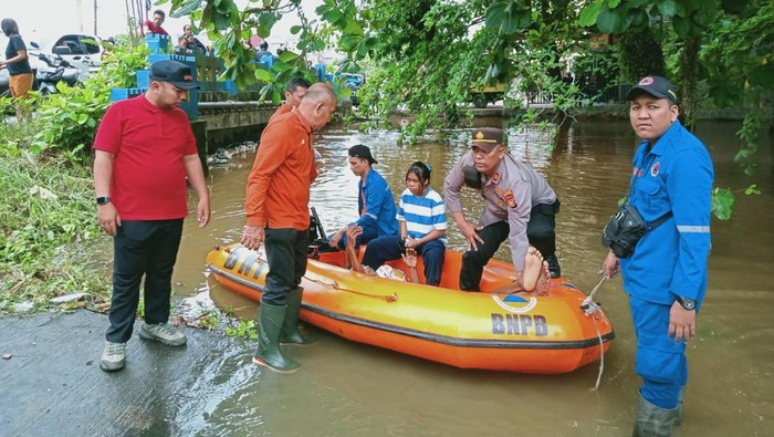 Polisi mengevakuasi lansia yang sakit dari perumahan yang terendam banjir di Payung Sekaki, Kota Pekanbaru, Riau, Kamis (10/9/2025).