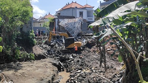Alat berat memindahkan material reruntuhan rumah korban banjir di Perumahan Permata Residence, Mengwitani, Badung, Jumat (12/9/2025). (Agus Eka/detikBali)