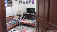 Puing-puing bangunan berserakan di jalan, sementara dinding dan atap rumah warga tampak roboh akibat kuatnya tekanan ledakan.