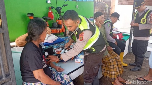 Petugas Dokkes Polres Jembrana melakukan pemeriksaan kesehatan terhadap warga terdampak banjir di Desa Pengambengan, Kecamatan Negara, Jembrana, Bali, Jumat (12/9/2025). (Foto: Putu Adi Budiastrawan/detikBali)