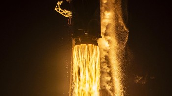 Roket Falcon 9 setinggi 70 meter dan berbobot 580 ton mengaum penuh kuasa, memancarkan semburan api oranye membara yang menerangi kegelapan. Foto: PSN