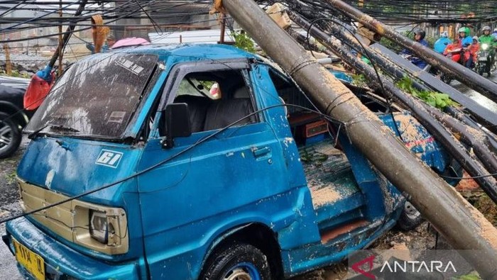 Satu mobil angkutan menjadi objek terdampak akibat satu pohon tumbang di Jalan Margasatwa Raya, Pondok Labu, Cilandak, Jakarta Selatan, Jumat (12/9/2025). ANTARA/Luthfia Miranda Putri.