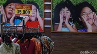 Kios busana yang masih buka terlihat tanpa pembeli, hanya penjaga yang menunggu.