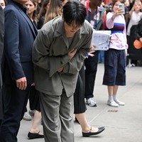 Begitu turun dari mobil, Jungkook BTS disambut kerumunan penggemar yang telah menunggu kedatangannya. Ia tampak membungkuk dan menundukkan kepala sebagai sapaan. Foto: Getty Images