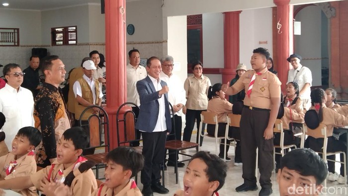 Menteri Lingkungan Hidup (LH), Hanif Faisol Nurofiq (pakai jas) saat mengunjungi SRMP 17 Tabanan di Sentra Mahatmiya, Desa Banjaranyar, Kecamatan Kediri, Tabanan, Sabtu (13/9/2025). (Krisna Pradipta)