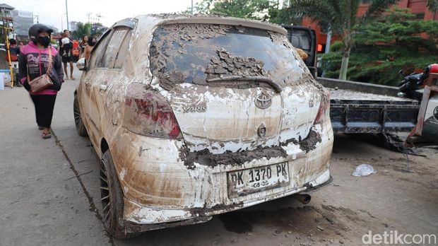 Mobil berlumur lumpur milik pedagang dan pengunjung Pasar Badung yang sudah dievakuasi dari area parkir basement, Sabtu (13/9/2025).