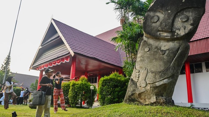 Sejumlah pelajar melintas di dekat replika Patung Tadulako situs megalit Bariri di Museum Daerah Sulteng di Palu, Sulawesi Tengah, Sabtu (13/9/2025). Pemerintah Provinsi Sulawesi Tengah sedang melengkapi dokumen untuk pengusulan sejumlah situs megalit yang berada di Kabupaten Poso dan Sigi sebagai warisan dunia UNESCO dan ditargetkan akan mendapat persetujuan pada 2028 mendatang. ANTARA FOTO/Basri Marzuki/nz