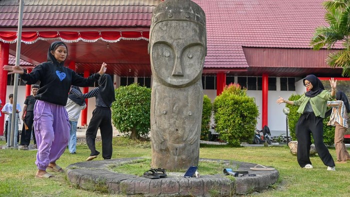Sejumlah pelajar melintas di dekat replika Patung Tadulako situs megalit Bariri di Museum Daerah Sulteng di Palu, Sulawesi Tengah, Sabtu (13/9/2025). Pemerintah Provinsi Sulawesi Tengah sedang melengkapi dokumen untuk pengusulan sejumlah situs megalit yang berada di Kabupaten Poso dan Sigi sebagai warisan dunia UNESCO dan ditargetkan akan mendapat persetujuan pada 2028 mendatang. ANTARA FOTO/Basri Marzuki/nz