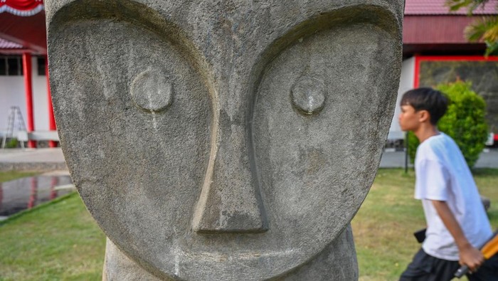 Sejumlah pelajar melintas di dekat replika Patung Tadulako situs megalit Bariri di Museum Daerah Sulteng di Palu, Sulawesi Tengah, Sabtu (13/9/2025). Pemerintah Provinsi Sulawesi Tengah sedang melengkapi dokumen untuk pengusulan sejumlah situs megalit yang berada di Kabupaten Poso dan Sigi sebagai warisan dunia UNESCO dan ditargetkan akan mendapat persetujuan pada 2028 mendatang. ANTARA FOTO/Basri Marzuki/nz