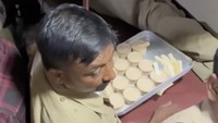 Penjual makanan asongan di kereta India menggunakan wadah-wadah jualan yang simpel. Seperti selembar nampan yang mengangkut dagangan kue. Foto: TikTok iamegamei