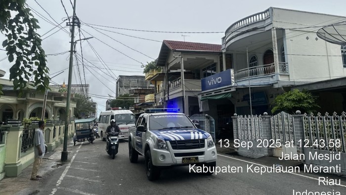 Polisi mengawal ambulans yang akan ke pemakaman