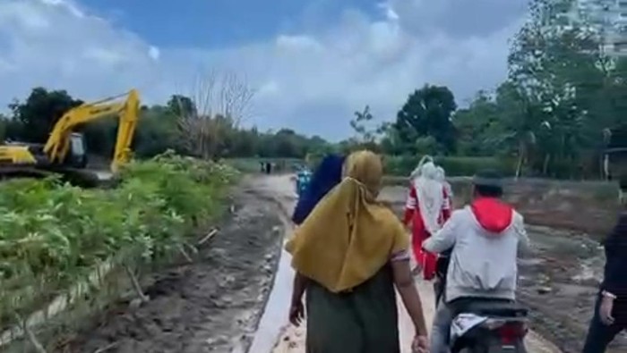 Sejumlah warga saat berjalan menuju lokasi tambang pasir di Gowa melakukan aksi demo.