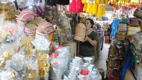 Seorang pedagang menata produk kerajinan di Pasar Badung, Denpasar, Bali, Minggu (14/9/2025), saat aktivitas mulai pulih pascabanjir. Foto: ANTARA FOTO/Nyoman Hendra Wibowo