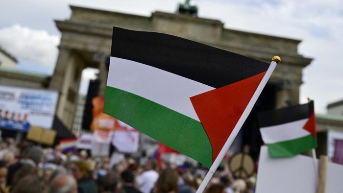 Demonstrators wave Palestinian flags during a peace rally titled Stop the genocide in Gaza! No weapons in war zones! Peace instead of arms race! on September 13, 2025 at the Brandenburg Gate in Berlin. (Photo by John MACDOUGALL / AFP)