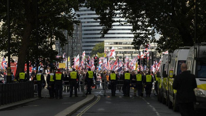 Jalanan London Bergolak, Aksi Anti-Imigrasi Pecah Jadi Bentrokan Police officers stand guard between an anti fascist group and Tommy Robinson supporters during an anti-immigration rally organised by British anti-immigration activist Stephen Yaxley-Lennon, also known as Tommy Robinson, in London, Britain, September 13, 2025. REUTERS/Jaimi Joy