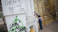 Seorang anggota tentara membersihkan grafiti dari pintu masuk utama kompleks perkantoran Singha Durbar yang merupakan kantor Perdana Menteri dan kementerian lainnya. Foto: REUTERS/Adnan Abidi