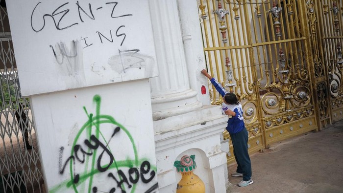 Jejak Kehancuran Pascademo Berdarah Guncang Nepal A member of the army removes graffiti from the main entrance of Singha Durbar office complex that houses the Prime Minister's office and other ministries, following Monday's deadly anti-corruption protests triggered by a social media ban, which was later lifted, in Kathmandu, Nepal September 12, 2025. REUTERS/Adnan Abidi
