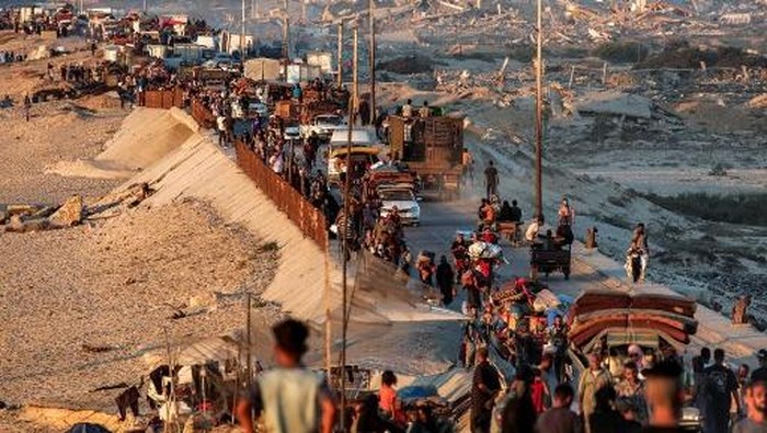 Displaced Palestinians evacuating southbound from Gaza City travel on foot and by vehicle along the coastal road in Nuseirat in the central Gaza Strip on September 13, 2025. The Israeli military said on September 13 that more than 250,000 people had fled Gaza City since it began intensifying operations there, as Palestinian officials reported many had been unable to evacuate south due to overcrowding. (Photo by Eyad BABA / AFP)
