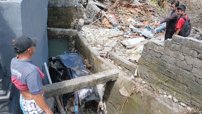 Warga menyaksikan rumah yang roboh akibat banjir di Perumahan Permata Residence, Desa Mengwitani, Badung, Bali, Sabtu (13/9/2025). Berdasarkan laporan terbaru dari BPBD Provinsi Bali terkait peristiwa banjir di kabupaten dan kota di Bali per Sabtu (13/9) mencatat sebanyak 205 titik banjir, 78 titik tanah longsor, 41 titik pohon tumbang, 25 titik tembok jebol, lima titik jalan rusak, dan dua titik jembatan rusak serta jumlah korban meninggal 17 orang dan lima warga yang hilang. ANTARA FOTO/Nyoman Hendra Wibowo/YU