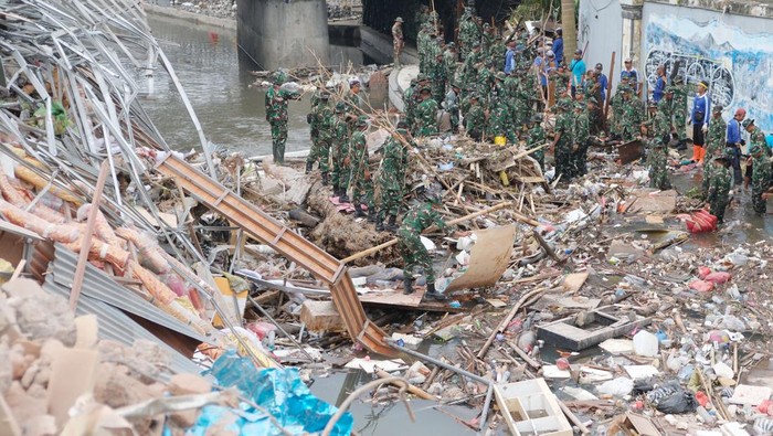 Warga negara asing (WNA) membersihkan lumpur dan sampah akibat bencana banjir di kawasan Sungai Badung, Denpasar, Bali, Minggu (14/9/2025). Sebanyak 500 orang dari unsur TNI, Polri, aparatur sipil negara (ASN), dan masyarakat bersama-sama membersihkan sampah, lumpur, dan puing-puing bangunan akibat bencana banjir tersebut untuk mendukung optimalisasi upaya penanganan pasca bencana serta pemulihan kawasan yang terdampak. ANTARA FOTO/Nyoman Hendra Wibowo/bar
