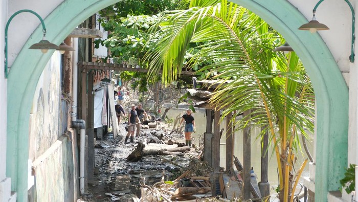 Potret WNA Ikut Gotong Royong Bersihkan Lumpur Pascabanjir di Bali Warga negara asing (WNA) membersihkan lumpur dan sampah akibat bencana banjir di kawasan Sungai Badung, Denpasar, Bali, Minggu (14/9/2025). Sebanyak 500 orang dari unsur TNI, Polri, aparatur sipil negara (ASN), dan masyarakat bersama-sama membersihkan sampah, lumpur, dan puing-puing bangunan akibat bencana banjir tersebut untuk mendukung optimalisasi upaya penanganan pasca bencana serta pemulihan kawasan yang terdampak. ANTARA FOTO/Nyoman Hendra Wibowo/bar