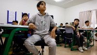 Siswa menyimak pelajaran di kelas. Manajer proyek, Diana Wardeh, dari pusat pendidikan tersebut, mengatakan prioritasnya adalah memastikan para siswa dapat menyelesaikan tahun ajaran mereka dan menerima sertifikat yang akan membantu mereka melanjutkan studi. Foto: REUTERS/Rula Rouhana