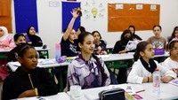Para siswa dari kelas satu hingga 12 duduk di meja mereka untuk mengejar pelajaran yang terlewat. Lebih dari 800 anak-anak Palestina yang mengungsi memulai tahun ajaran baru di sana. Foto: REUTERS/Rula Rouhana