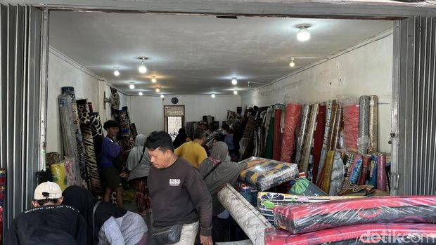 Toko di Jalan Gajah Mada, Denpasar, yang mengobral barang dagangan bekas banjir, Minggu (14/9/2025).