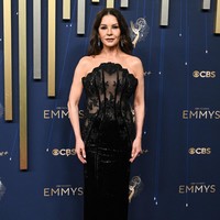 Sang ikon glamour, Catherine Zeta-Jones, memukau dengan gaun merah anggur dari Yara Shoemaker Couture. Siluet klasik yang dipadukan dengan cape dramatis membuatnya tampil megah, seakan membawa kemewahan era old Hollywood ke masa kini. Foto: Michael Buckner/Variety via Getty Images