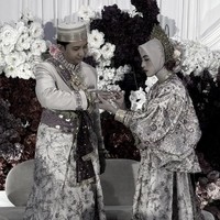 Dalam salah satu momen sakral, Adam terlihat memasangkan cincin ke jari manis Feby. Nuansa adat Bugis tampak begitu kental lewat pakaian berpotongan longgar dengan detail bordir penuh payet berkilau serta prosesi di acara pernikahan. Foto: Instagram/@fbyputrinc