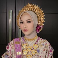 Riasan Feby dikerjakan dengan detail yang halus, alis tegas, riasan mata dramatis namun tetap elegan, serta lipstik pink nude yang membuat wajahnya segar. Dipadukan dengan hijab simple dan hiasan kepala emas, penampilan Feby terlihat manglingi. Foto: Instagram/@fbyputrinc