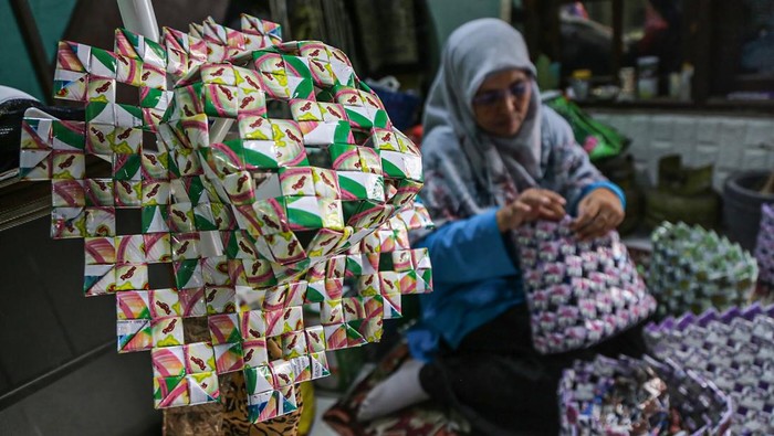 Anggota Bank Sampah Resik Becik membuat tas anyaman berbahan baku sampah kertas di Bank Sampah Resik Becik, Semarang, Jawa Tengah, Sabtu (13/9/2025). Rumah kreatif Bank Sampah Resik Becik dalam sebulan mampu mengolah 500-700 kilogram sampah plastik, kertas, dan minyak jelantah untuk diproduksi menjadi berbagai kreasi kerajinan seperti tas, dompet, topi, gantungan kunci, lilin jelantah, hiasan dinding dan meja yang dijual Rp5 ribu hingga Rp700 ribu dan dipasarkan ke daerah Kabupaten/Kota Semarang serta dibeli wisatawan mancanegara ketika berkunjung ke bank sampah itu. ANTARA FOTO/Makna Zaezar/sgd