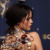 Atasan bergaya halter tersebut dipadukan dengan rok hitam berbelahan tinggi, yang semakin mengaksentuasi aura seksinya. Gaya glamornya dilengkapi stiletto hitam bertali, anting mutiara, cincin statement, dan gelang dari Pomellato. Foto: Getty Images