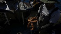 Pot plastik pecah saat ditarik ke permukaan, menunjukkan betapa rapuh namun berbahayanya sampah laut ini bagi ekosistem. Foto: REUTERS/Stelios Misinas
