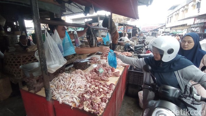 Pedagang daging ayam di Pasar Cikurubuk Tasikmalaya sedang melayani pembeli.