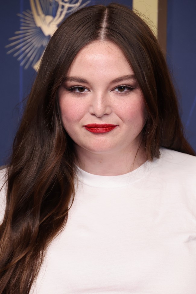 Dalam penampilannya di Emmy Awards, sang komedian menambahkan sentuhan warna yang halus dengan lipstik merah dan cat kuku merah. Rambutnya yang panjang dan gelap dibelah tengah dan ditata bergelombang. Foto: Getty Images/Emma McIntyre