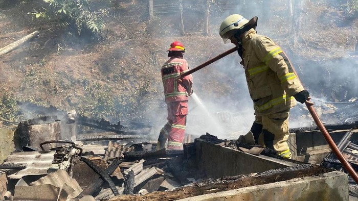 Petugas Damkar Pos WMK Banjarsari memadamkan api yang membakar rumah warga.