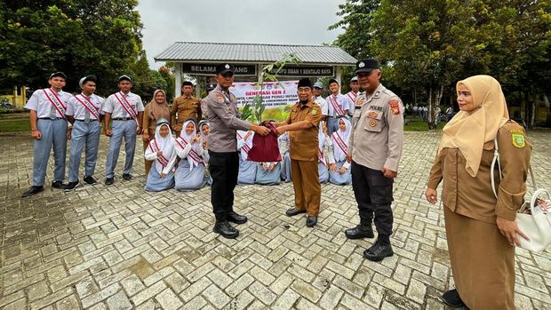 Polres Kuansing turun ke sekolah ajarkan siswa SMA cinta lingkungan dengan menanam pohon.