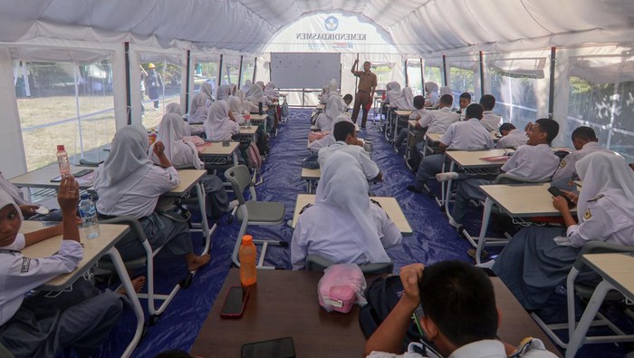 Sejumlah siswa belajar di halaman sekolah SMKN 1 Cileungsi, Kabupaten Bogor, Jawa Barat, Senin (15/9/2025). Kementerian Pendidikan Dasar dan Menengah membangun tiga tenda sebagai ruang kelas darurat guna mendukung kegiatan belajar mengajar usai atap sekolah tersebut roboh pada Rabu (10/9). ANTARA FOTO/Yulius Satria Wijaya