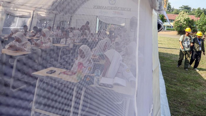 Sejumlah siswa belajar di halaman sekolah SMKN 1 Cileungsi, Kabupaten Bogor, Jawa Barat, Senin (15/9/2025). Kementerian Pendidikan Dasar dan Menengah membangun tiga tenda sebagai ruang kelas darurat guna mendukung kegiatan belajar mengajar usai atap sekolah tersebut roboh pada Rabu (10/9). ANTARA FOTO/Yulius Satria Wijaya