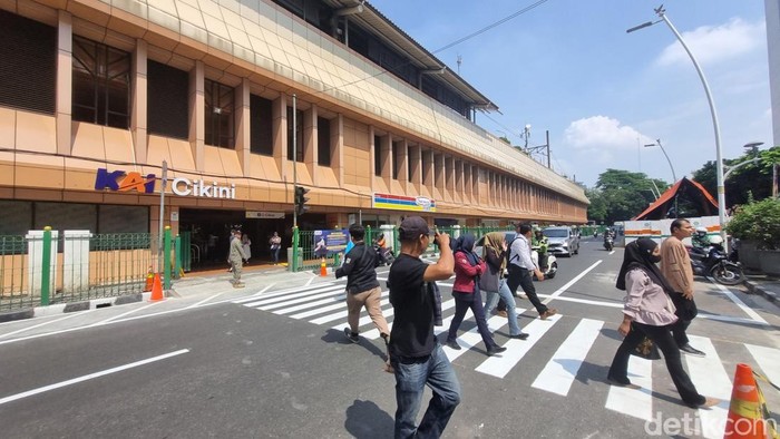 Warga menyeberang di pelican crossing di Stasiun Cikini, Jakarta Pusat.