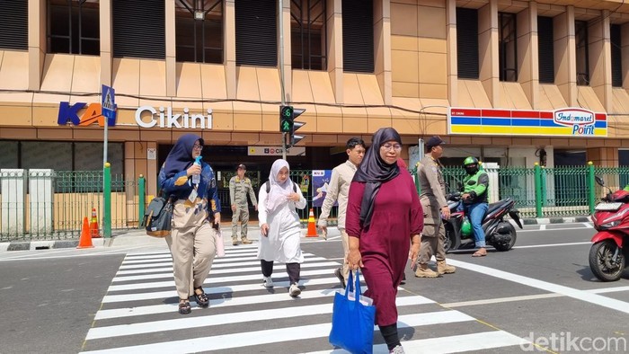 Warga menyeberang di pelican crossing di Stasiun Cikini, Jakarta Pusat.